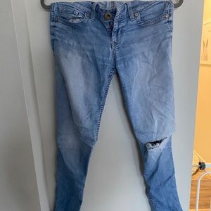 Blue jeans, distressed with rip on the knee